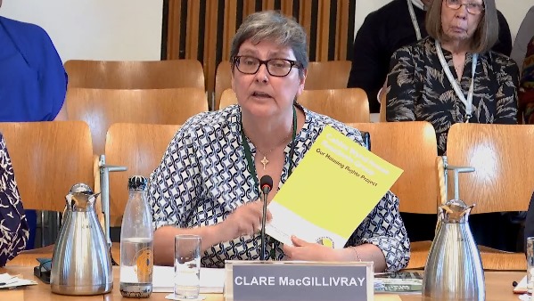 Clare holds up the Cables Wynd Housing Report